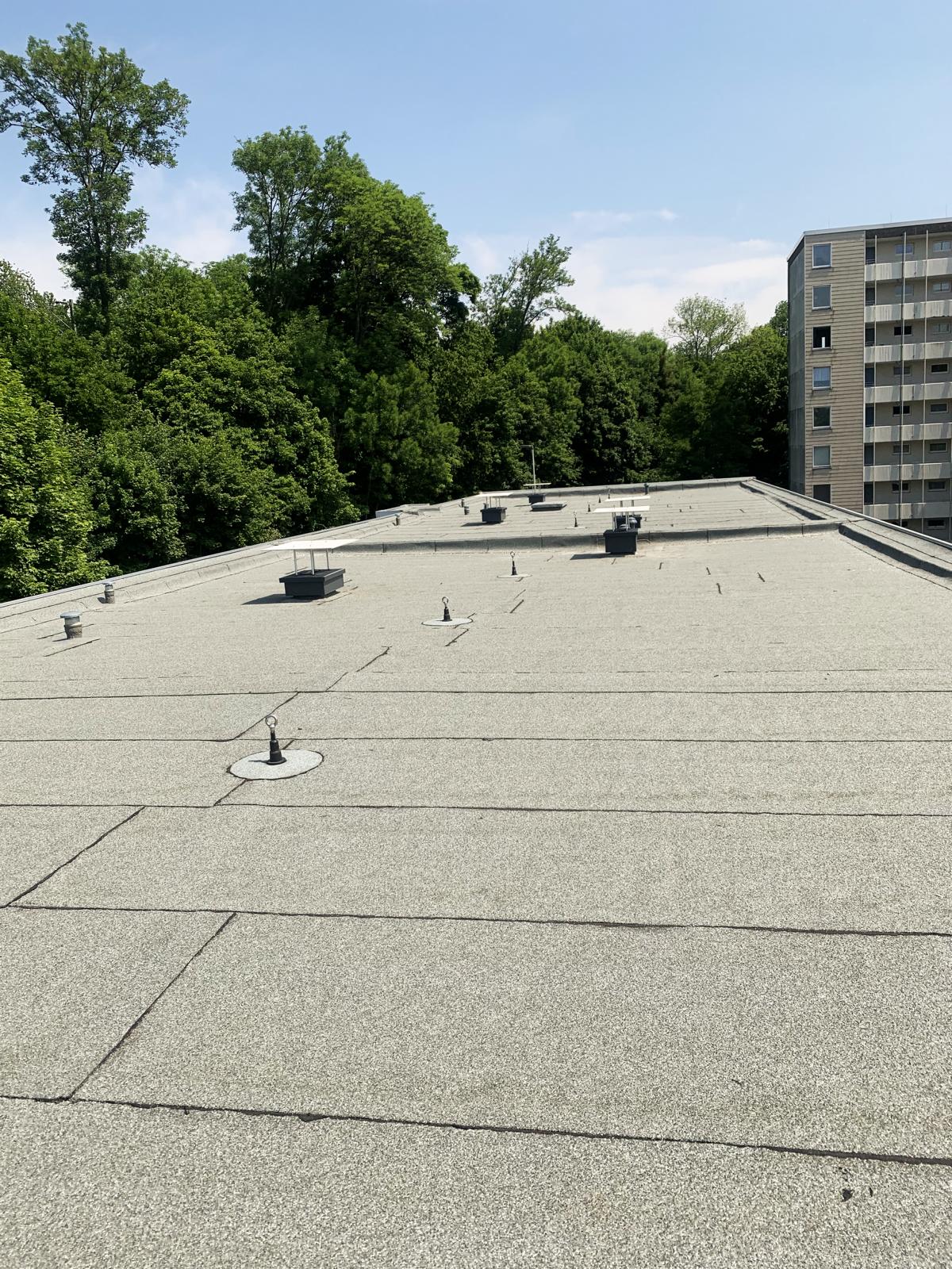 Das Bild zeigt eine sanierte Flachdachfläche. Die Bauwerksabdichtung bzw. Flachdachabdichtung wurde mithilfe von Bitumenbahnen gewährleistet.