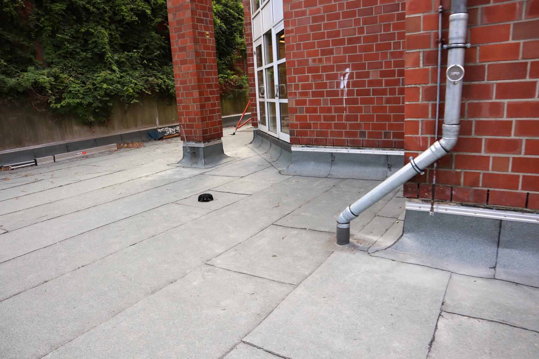 Das Bild zeigt den Teilbereich eines durch die KKOe Beratende Ingenieure Kempis Kleisa PartG mbB instandgesetzten Flachdachs, welches gleichzeitig die Deckenplatte einer Tiefgarage darstellt. Das Flachdach war vor der Reparatur undicht. Die KKOe bzw. deren Bauleiter haben die Flachdachsanierung überwacht.