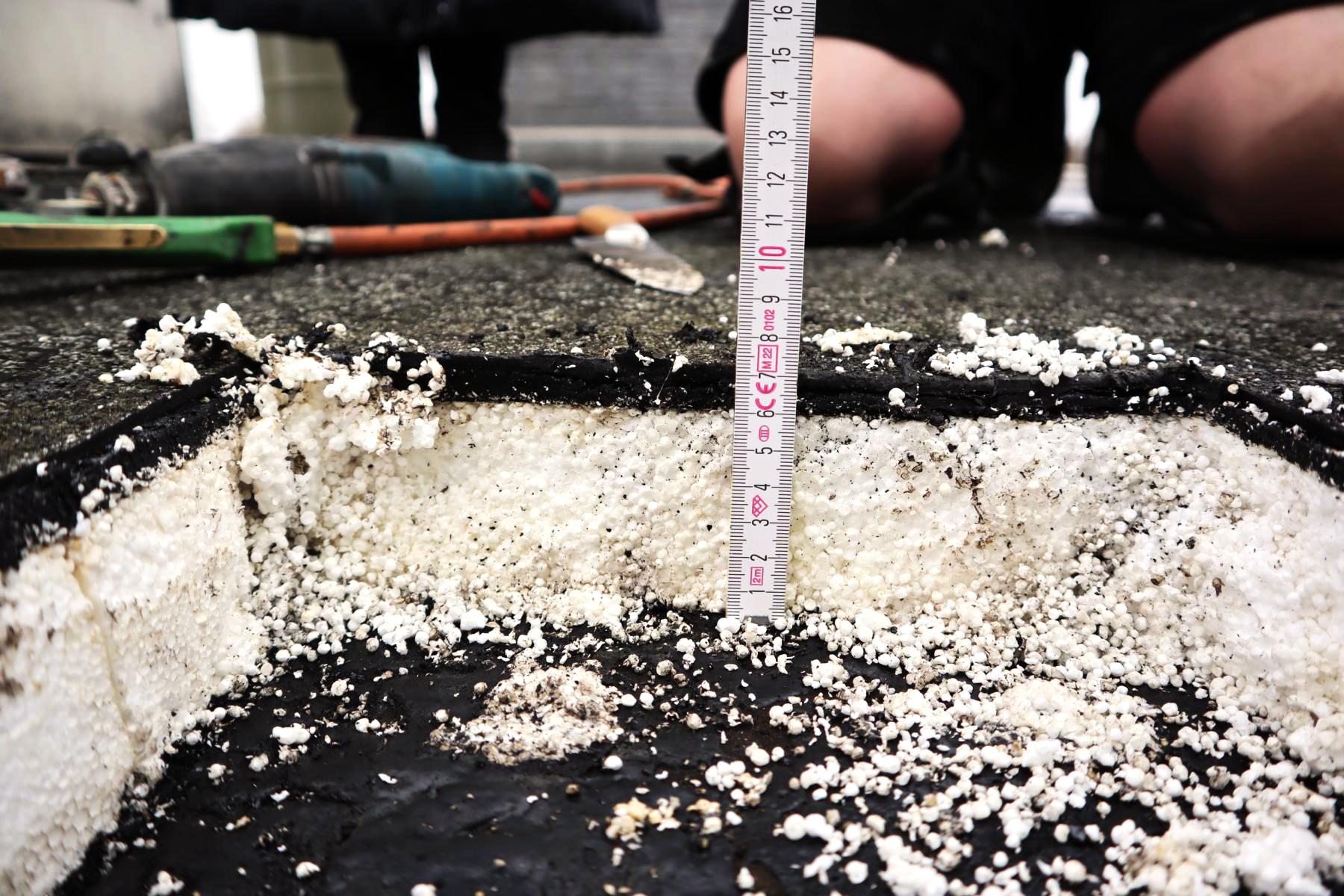 Das Bild zeigt eine nicht zerstörungsfreie Bauteilöffnung im Rahmen einer Bauwerksuntersuchung. Das Ziel der Untersuchung war die Charakterisierung des Dachaufbaus, was Teil der Bauplanung der Flachdachsanierung ist.