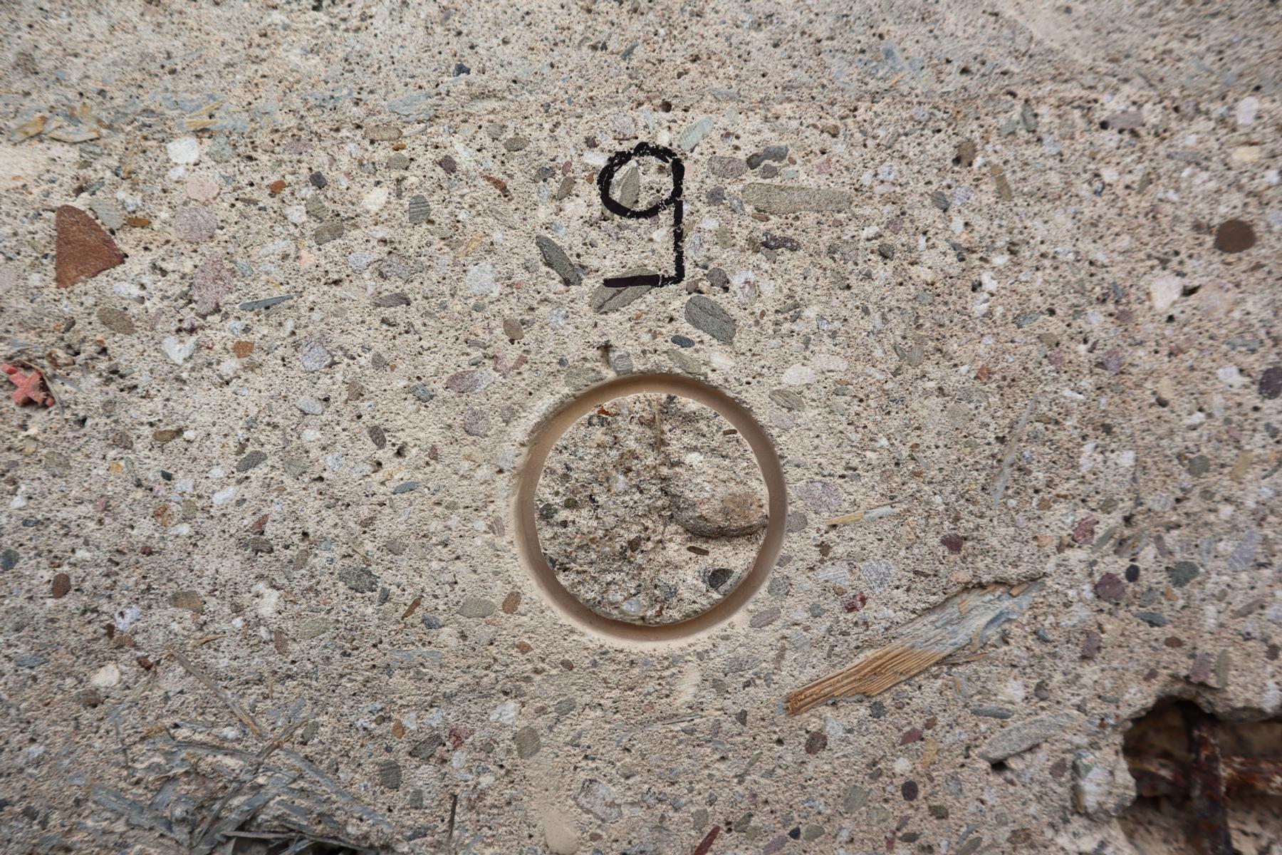 Prüfstelle nach Durchführung des Abreißversuchs (Kohäsionsbruch) Das Bild zeigt eine Prüfstelle eines oberflächennahen Betons, dessen Oberflächenzugfestigkeit im Rahmen einer Bauwerksuntersuchung ermittelt wurde. Es handelt sich hierbei um einen sogenannten Kohäsionsbruch (d. h. der Beton versagte während der Oberflächenzugfestigkeitsprüfung in seinem "Inneren").