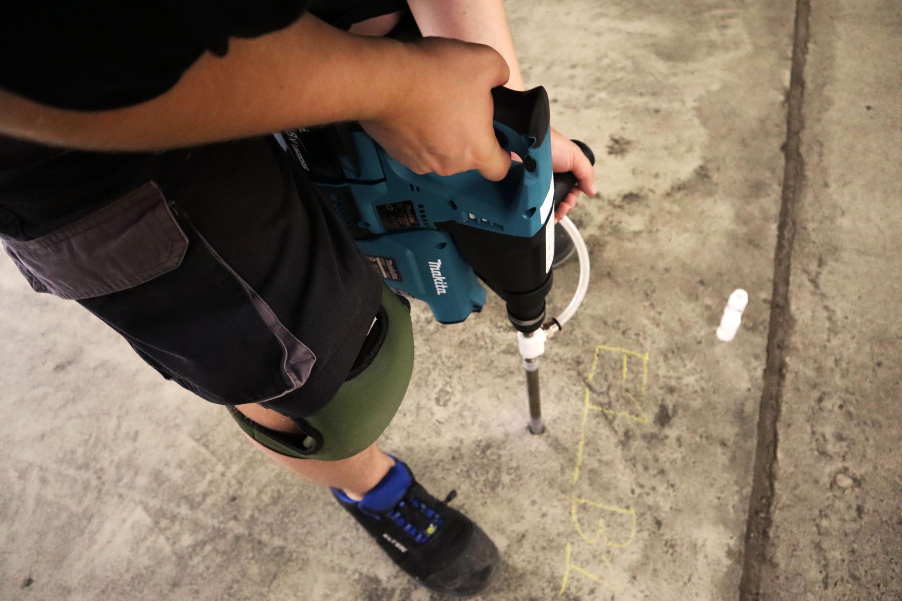 Bohrmehlprobenentnahme aus einer Stahlbetonbodenplatte einer Tiefgarage Das Bild zeigt einen Techniker der KKOe Beratende Ingenieure und Bausachverständige, der mithilfe eines Spezialbohrgeräts Bohrmehlproben aus einer Stahlbetonplatte einer Tiefgarage entnimmt. Die Bohrmehlproben werden anschließend in ein Labor geschickt, damit der Chloridgehalt im Beton festgestellt werden kann.