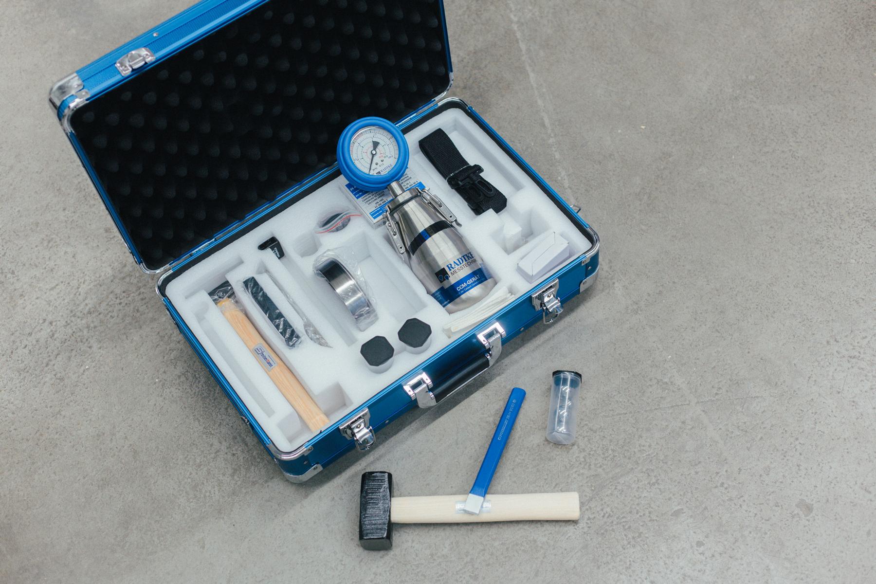 Das Bild zeigt verschiedene Utensilien in einem Koffer, welche für die CM-Prüfung zwecks Bestimmung der Feuchtigkeit eines Estrichs oder auch Betons genutzt werden.