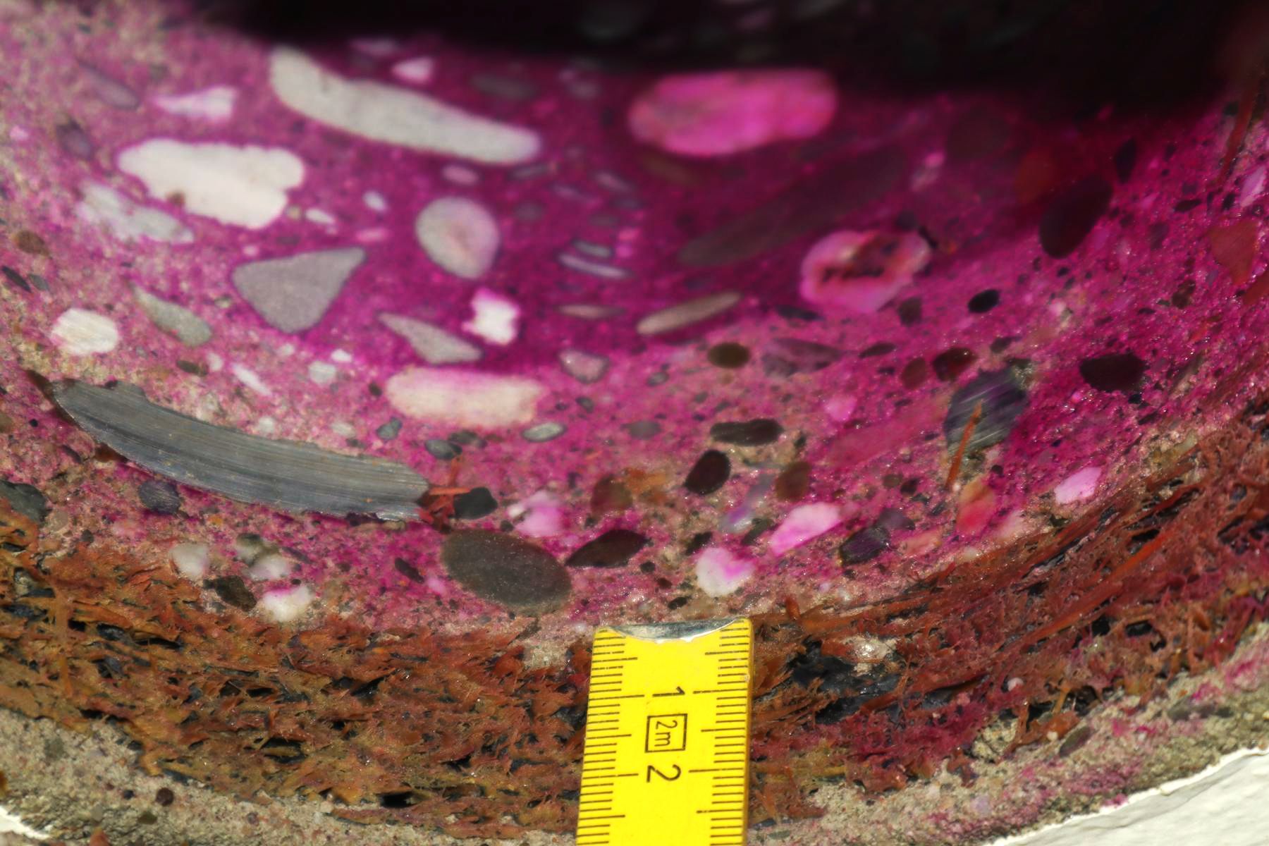 Prüfung der Karbonatisierungstiefe an einer Balkontragplatte nach einer Kernlochbohrung Das Bild zeigt die Prüfung der Karbonatisierung mit einem Zollstock an der Unterseite einer Balkontragplatte (aus Beton) nach einer Kernlochbohrung